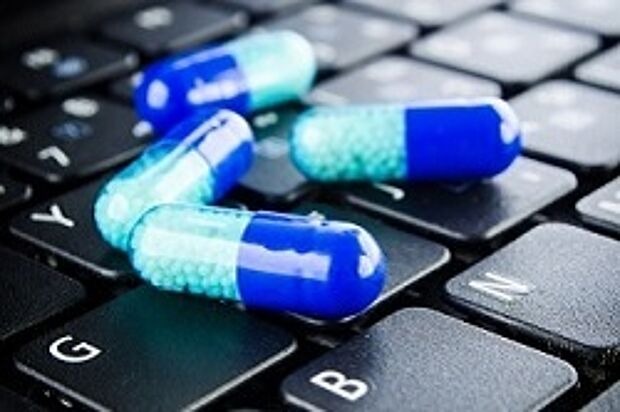 blaue Pillen auf einer Computer Tastatur