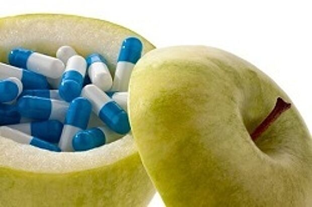 aufgeschnittener und ausgehöhlter Apfel mit Tabletten drin