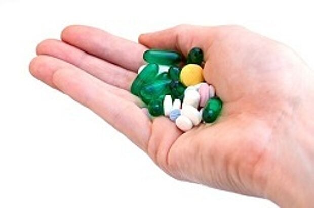 offene Hand hält viele bunte Tabletten in der Handfläche