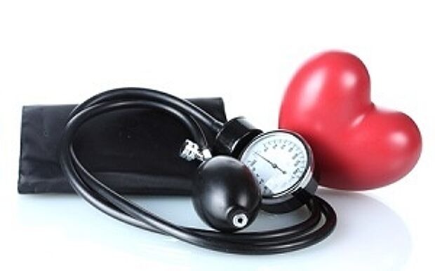 Blutdruckmanschette und Herz vor weißem Hintergrund