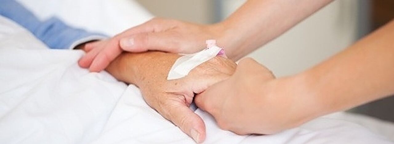 Nahaufnahme einer Pflegeperson, die Hand eines Patienten hält