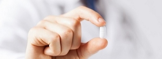 Meikamente - Arzt hält Tablette zwischen den Fingern Arzt hält Tabletten zwischen Fingern